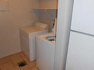 Laundry room featuring light tile patterned flooring and independent washer and dryer