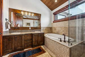 Bathroom with a vaulted wood ceiling, double vanity, a bath, and a shower stall
