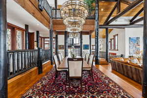 Dining space with hardwood / wood-style flooring, hanging lights, and lofted ceiling