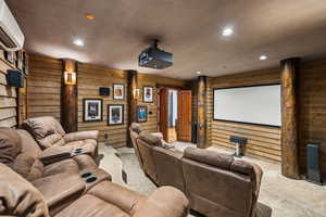 Carpeted cinema featuring recessed lighting, wood walls, and a heating unit