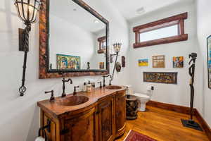 Bathroom featuring double vanity, light wood-style flooring, and recessed lighting
