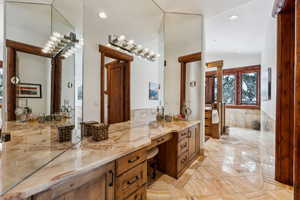 Bathroom featuring recessed lighting, vanity, and vaulted ceiling