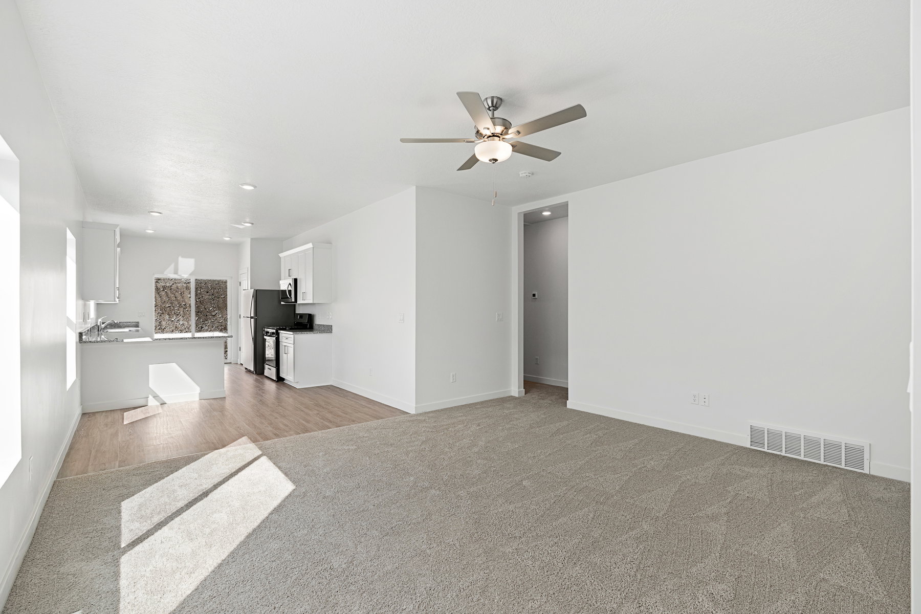 Unfurnished living room featuring a ceiling fan, light carpet, and recessed lighting