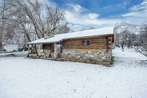 View of front of home with a chimney and log siding