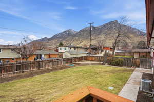 Fenced backyard featuring a residential view and a mountain view