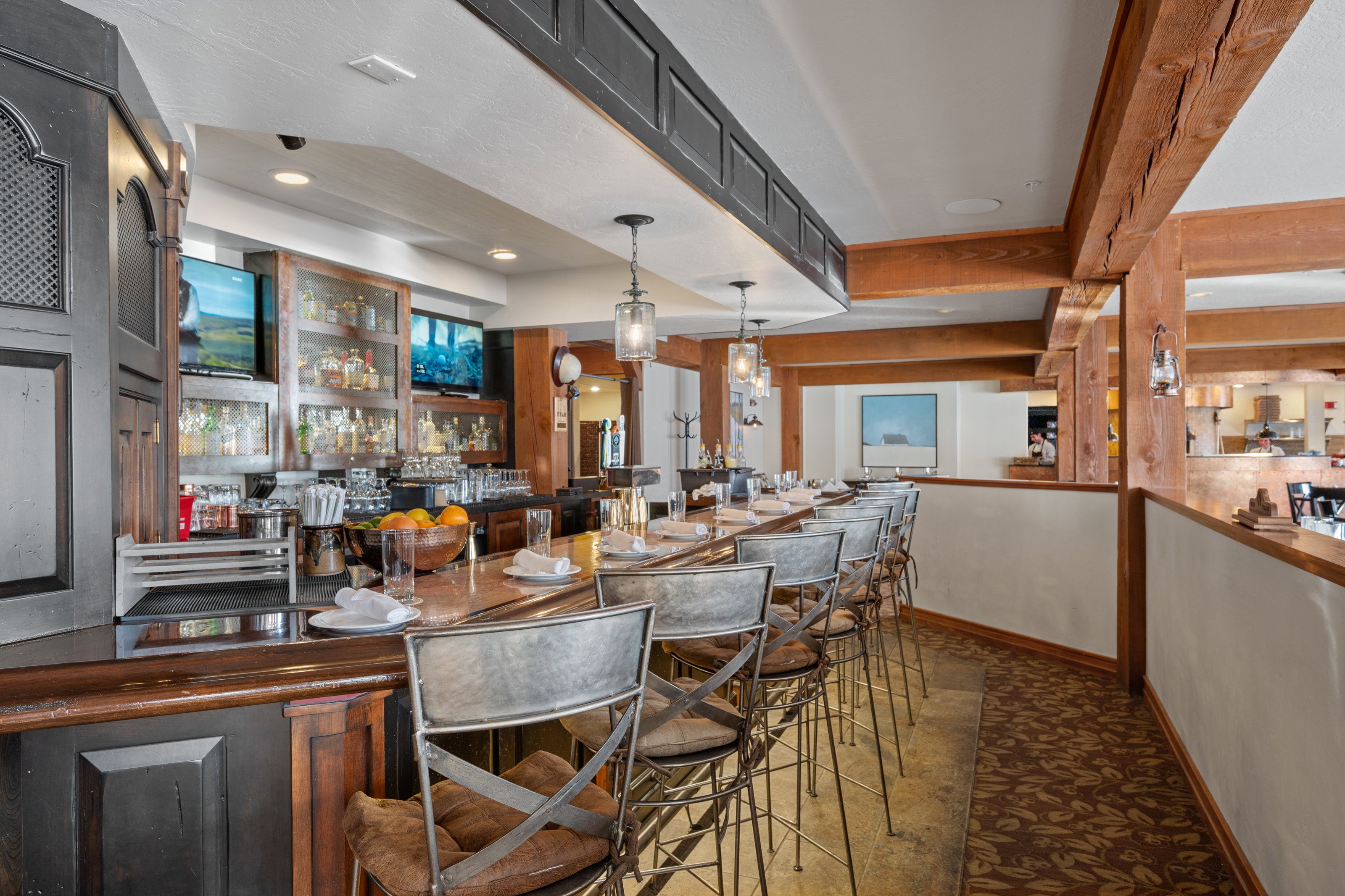 Indoor wet bar with decorative light fixtures and dark countertops