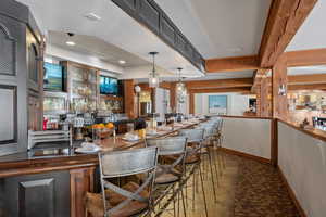 Indoor wet bar with decorative light fixtures and dark countertops