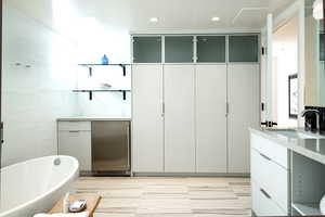 Full bathroom with vanity and a soaking tub