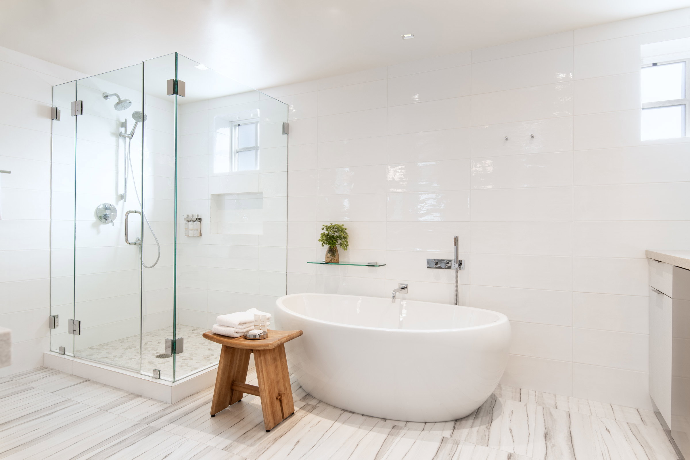Bathroom featuring a stall shower, a soaking tub, healthy amount of natural light, tile walls, and vanity