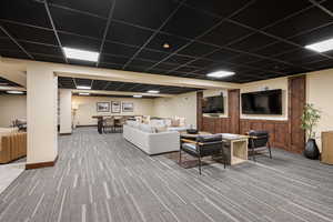 Living room with light carpet and a drop ceiling