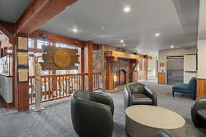 Living area with carpet flooring, elevator, a fireplace, and recessed lighting