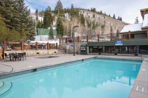 Community pool with a patio and a mountain view