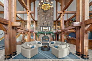 Living area featuring a high ceiling, a fireplace, wood finished floors, and hanging lights
