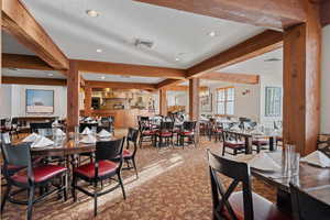 Carpeted dining room with beam ceiling, recessed lighting, and a textured ceiling