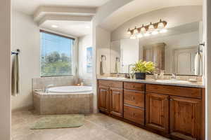 Full bathroom featuring double vanity, a bath, light tile patterned flooring, and recessed lighting