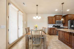 Dining area with suspended lighting and light tile patterned floors