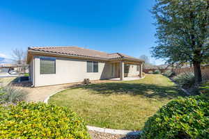 Rear view of property featuring stucco siding, a patio, a fenced backyard, and a tiled roof