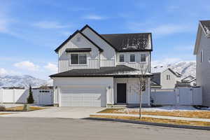 Modern inspired farmhouse with a gate, a mountain view, a shingled roof, and driveway