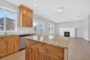 Kitchen featuring light stone countertops, light wood-style flooring, and decorative backsplash