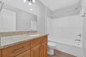 Bathroom with vanity, light wood finished floors, and shower / bath combination
