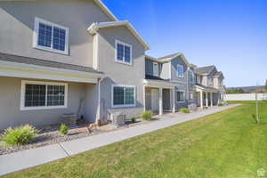 Rear view of property with a residential view, a yard, stucco siding, and covered porch