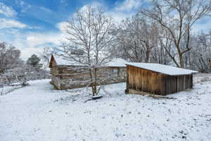 View of snowy exterior with stone siding