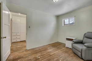 Sitting room with light wood finished floors and ornamental molding