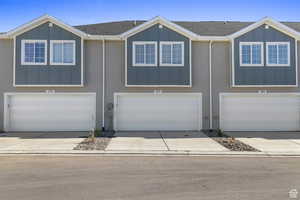 View of front of home featuring board and batten siding, a shingled roof, an attached garage, and concrete driveway