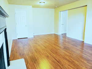 Unfurnished living room with light wood finished floors and a textured ceiling