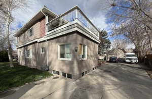 View of side of home featuring a detached garage and a lawn