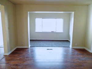 Spare room with dark wood-type flooring