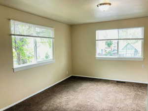 Carpeted empty room with baseboards