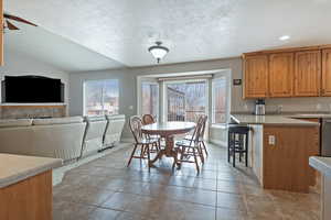 Dining area with a textured ceiling, light tile patterned floors, and a ceiling fan