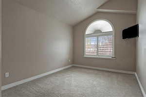 Unfurnished room featuring light carpet and baseboards