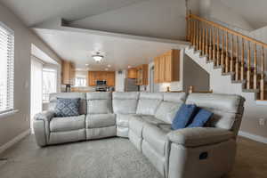 Living room featuring light carpet, vaulted ceiling, and recessed lighting