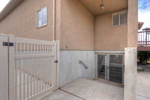Property entrance featuring a gate and stucco siding