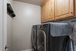Laundry room featuring separate washer and dryer and cabinet space