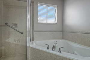 Bathroom with a shower stall and a whirlpool tub