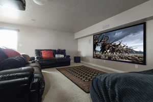 Carpeted living area featuring a textured ceiling and baseboards