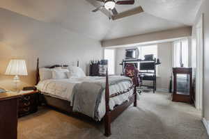 Bedroom with carpet, a ceiling fan, and vaulted ceiling