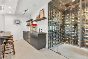 Wine area featuring rail lighting and baseboards