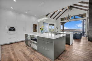 Kitchen featuring modern cabinets, dark wood-style flooring, and dual tone cabinetry