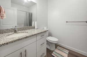 Bathroom featuring vanity, a shower with shower curtain, and dark wood-style floors