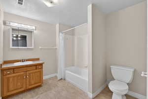 Full bathroom featuring vanity, a textured ceiling, and shower / bath combo