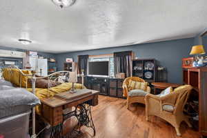 Living area with hardwood / wood-style flooring and a textured ceiling