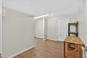 Basement Hall with light wood-style floors and baseboards