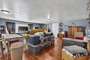 Living area featuring hardwood / wood-style floors and a textured ceiling