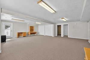 Huge Basement Family room with light colored carpet and a textured ceiling with Daylight windows and entrance