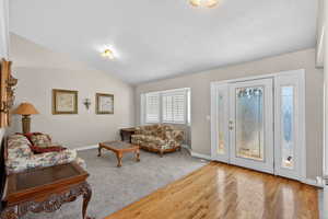Living area with light wood-type flooring and lofted ceiling