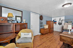 Living area featuring wood finished floors and a textured ceiling